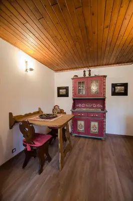 a dining room with a table and a red cabinet at La Roncolina in Cortina dʼAmpezzo