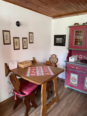 a dining room with a wooden table and a stove at La Roncolina in Cortina dʼAmpezzo