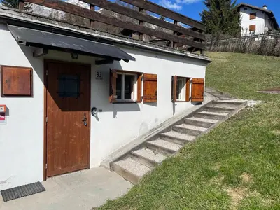 a white building with a staircase leading to a door at La Roncolina in Cortina dʼAmpezzo