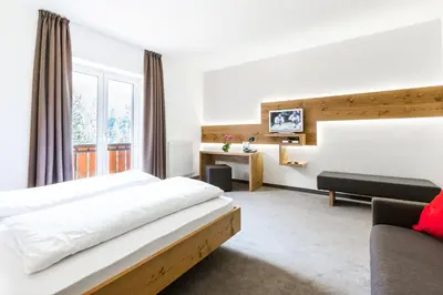 a hotel room with a bed and a couch at Zur Mühle Wohlfühloase in Trodena