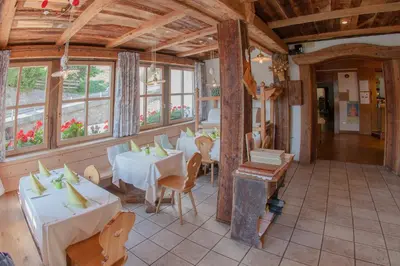 a restaurant with tables and chairs and windows at Zur Mühle Wohlfühloase in Trodena