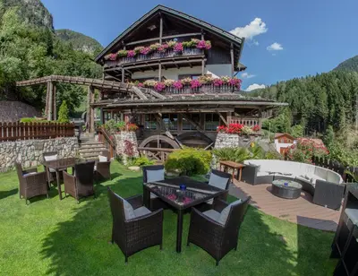 a house with a table and chairs in the yard at Zur Mühle Wohlfühloase in Trodena