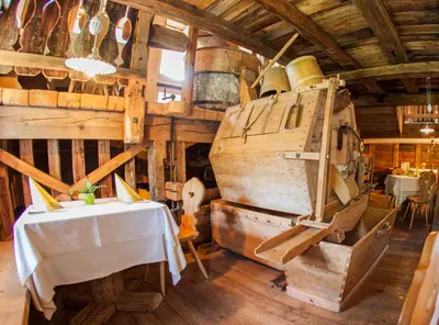a dining room with a table and a large wooden room at Zur Mühle Wohlfühloase in Trodena