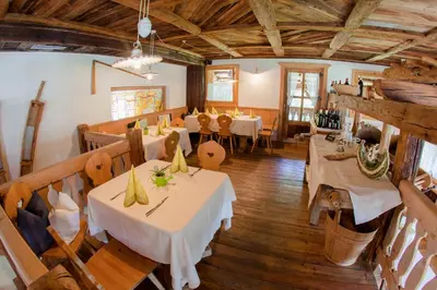 a restaurant with tables and chairs in a room at Zur Mühle Wohlfühloase in Trodena