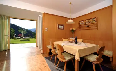 a dining room with a table and chairs and a window at Villa Tanja in Castelrotto