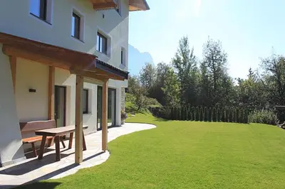 a house with a picnic bench next to a lawn at Villa Tanja in Castelrotto