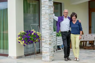 a man and a woman standing next to a column at Villa Tanja in Castelrotto