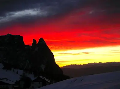 a sunset over a mountain with a red sky at Villa Tanja in Castelrotto
