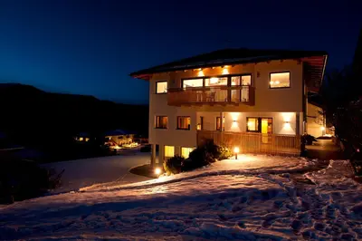 a house in the snow at night at Villa Tanja in Castelrotto