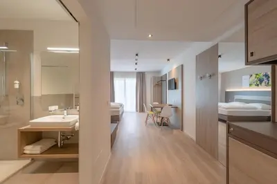 a bathroom with a sink and a bedroom with a bed at Vineus Tramin in Termeno