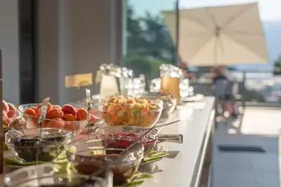 a buffet line with bowls of fruit on a table at Vineus Tramin in Termeno
