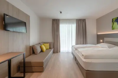 a hotel room with a bed and a couch at Vineus Tramin in Termeno