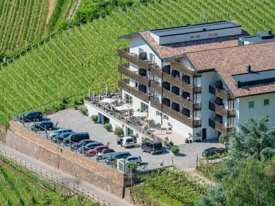 an aerial view of a hotel with a parking lot at Vineus Tramin in Termeno