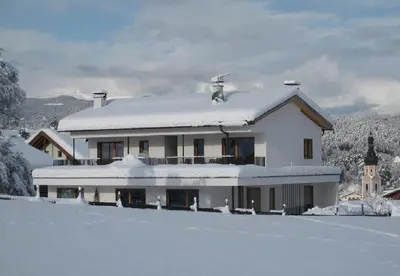 a white house with snow on top of it at Apartments Elisir in Castelrotto