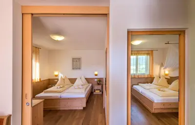 a room with two beds and a mirror at Apartments Elisir in Castelrotto