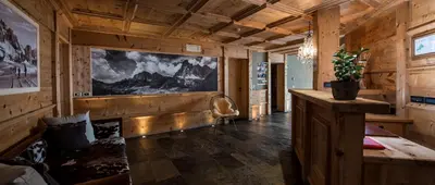 a room with wooden walls and a large painting on the wall at Nei Y Suredl NeveSole in Corvara in Badia