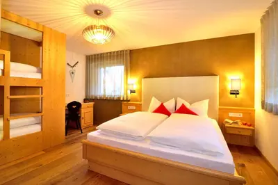 a bedroom with a large white bed with red pillows at Appartements Mayrhof in Bressanone