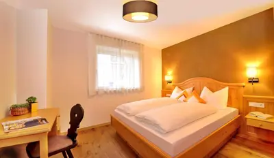 a bedroom with a bed and a desk and a bed sidx sidx sidx at Appartements Mayrhof in Bressanone