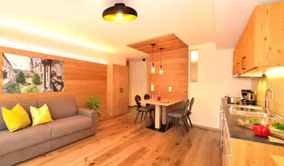a living room and kitchen with a couch and a table at Appartements Mayrhof in Bressanone