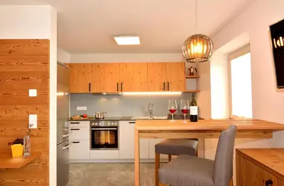a kitchen with a wooden table with wine glasses at Appartements Mayrhof in Bressanone