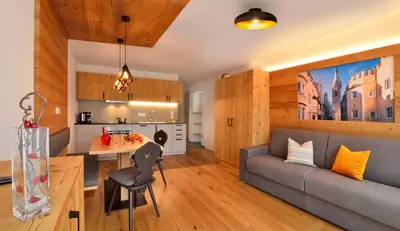 a living room and kitchen with a couch and a table at Appartements Mayrhof in Bressanone