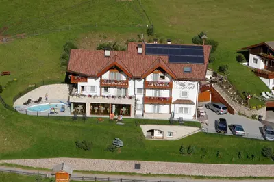 an aerial view of a house with a solar roof at Garni La Tambra in Selva di Val Gardena