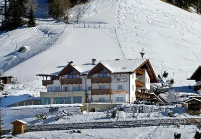 a large house in the snow with snow at Garni La Tambra in Selva di Val Gardena
