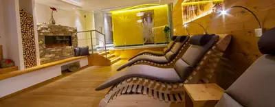 a bench in a room with a fireplace at Garni Hotel Miara - Your Dolomites Home in Selva di Val Gardena