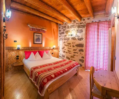 a bedroom with a bed and a table in a room at Castel Madonna in San Martino di Castrozza