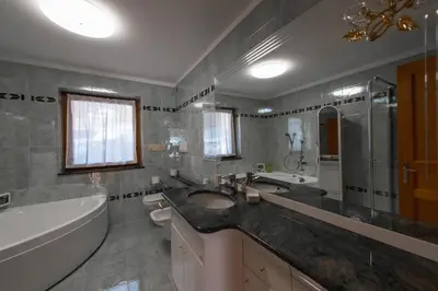 a bathroom with a sink and a bath tub and a tub at Appartamenti Majon Ladina in Vigo di Fassa