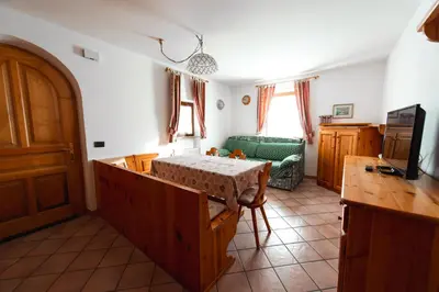 a living room with a table and a couch at Appartamenti Majon Ladina in Vigo di Fassa