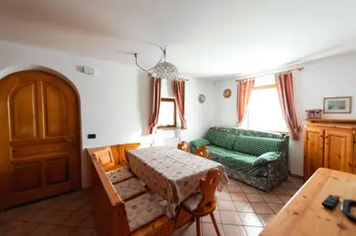 a living room with a green couch and a table at Appartamenti Majon Ladina in Vigo di Fassa