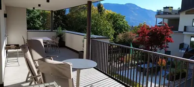 a balcony with a table and chairs and a view of a mountain at Marlingsuites - Vinea - Wieser Josef - Marling in Marlengo