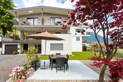 a house with a table and an umbrella at Marlingsuites - Vinea - Wieser Josef - Marling in Marlengo