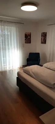 a bedroom with two beds and a blue chair at Marlingsuites - Vinea - Wieser Josef - Marling in Marlengo