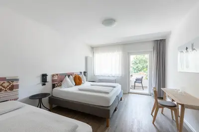 a hotel room with two beds and a window at Gasthof Salurn in Salorno sulla Strada del Vino