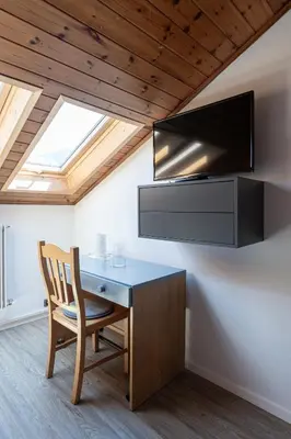 a room with a desk and a television on a ceiling at Gasthof Salurn in Salorno sulla Strada del Vino