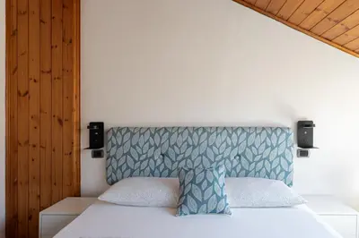 a bedroom with a white bed with a blue headboard at Gasthof Salurn in Salorno sulla Strada del Vino