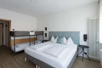 a bedroom with a bed and a bunk bed at Gasthof Salurn in Salorno sulla Strada del Vino