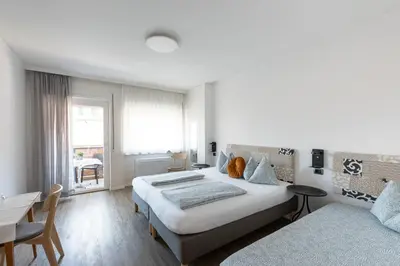 a bedroom with two beds and a table and a desk at Gasthof Salurn in Salorno sulla Strada del Vino