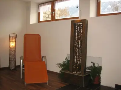 a room with a mirror and a chair and a lamp at Garni - Appartement Neumairhof in Rasun di Sopra
