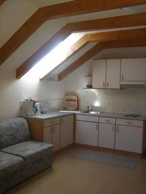 a kitchen with white cabinets and a couch in a room at Garni - Appartement Neumairhof in Rasun di Sopra