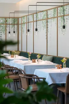 a row of tables with white tablecloths and chairs at VillaVerde Aparthotel in Lagundo