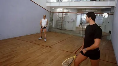 two people standing on a court with tennis rackets at Hotel San Marco in Passo San Pellegrino