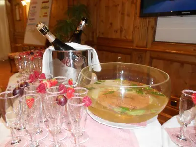 a bottle of champagne in a bowl on a table with wine glasses at Hotel San Marco in Passo San Pellegrino