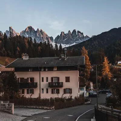 a white house with mountains in the background at Hotel Fines in Funes