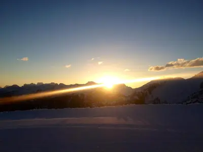 a sunset in the mountains with snow on the ground at Chalet Paoletta - Alpe Cermis in Cavalese