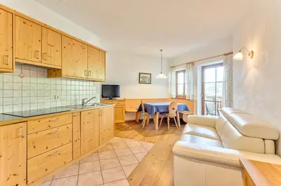 a kitchen and living room with a couch and a table at Gasserhof in Barbiano