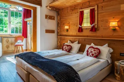 a bedroom with two beds in a room with wooden walls at Hotel Rio Bianco in Panchia