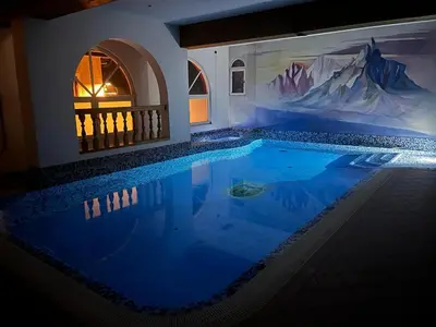 a swimming pool in a house with a painting on the wall at Hotel Rio Bianco in Panchia